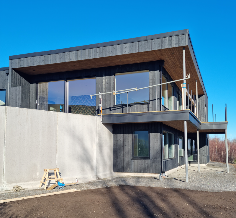 Ett modernt hus med svart fasad.